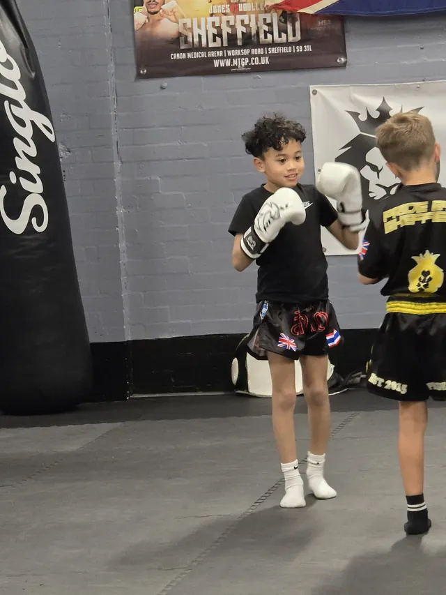 Smiling boy with his guard up during a kids Muay Thai class