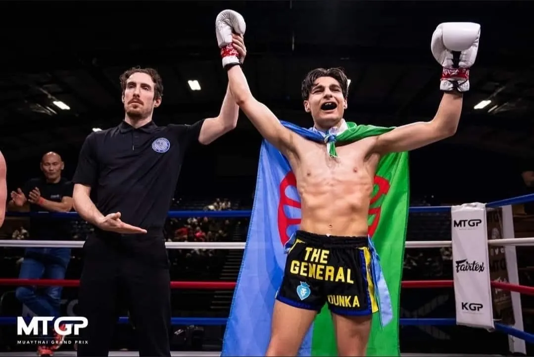 Pride Gym fighter celebrating a win with his arms raised at an MTGP fight night